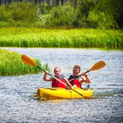 man and woman kayaking on river